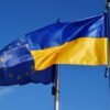 Low Angle View Of Ukrainian And European Union Flags Against Blue Sky